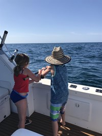 Kids on Fishing Charter Reeling in Big Fish